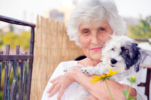 un vielle dame tient un petit chien dans ses bras