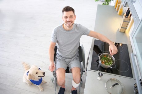 En mann i rullestol forbereder suppe til hunden sin