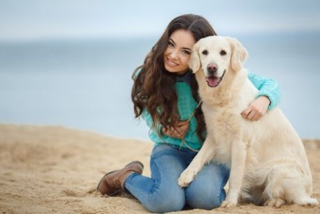 En jente og hunden hennes på stranden