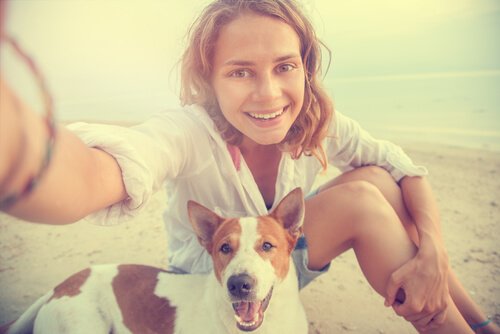 Vrouw met haar hond op het strand
