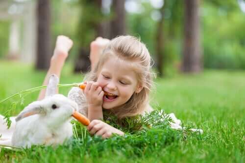 Meisje en konijn eten een wortel