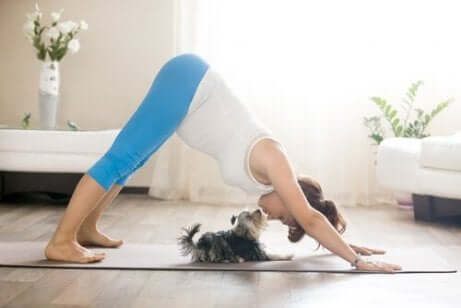 Een vrouw doet yoga met haar hond