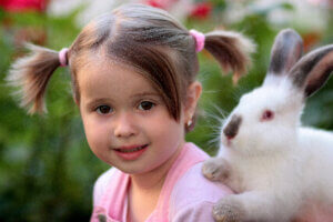 Dziewczynka siedzi z królikiem