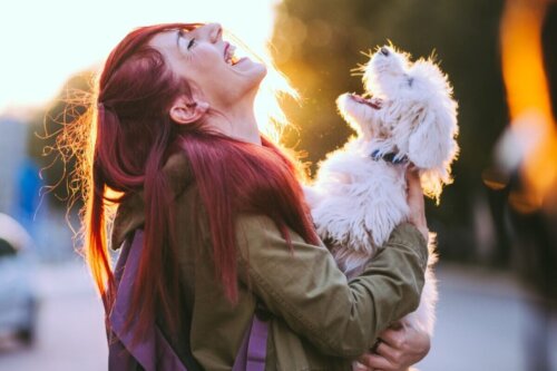 Kobieta różowe włosy trzyma psa na rękach. rdzennie amerykańskie imiona.