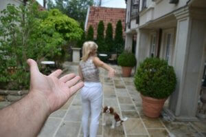 En kvinna och hund rör sig bort från en utsträckt hand