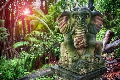 Stenstaty av en elefant i djungel.