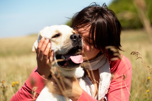 A woman hugging her happy dog.