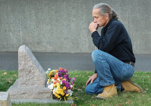 Man visiting his deceased pet at a cemetery  