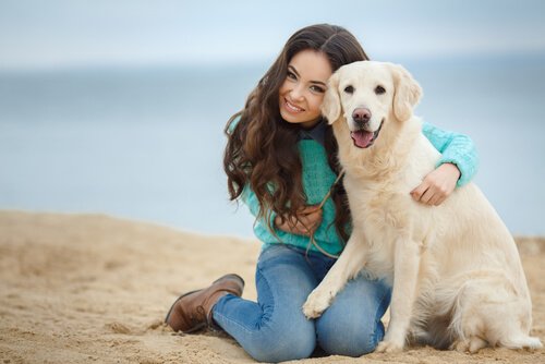 A girl and her dog on the beach.
