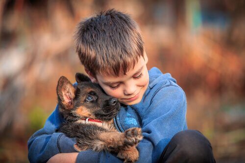 A boy cuddling his dog.