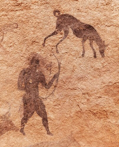 A cave painting of a hunter with his dog.