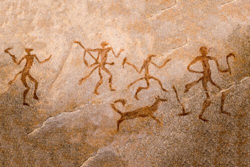 Some people and a dog in a cave painting.