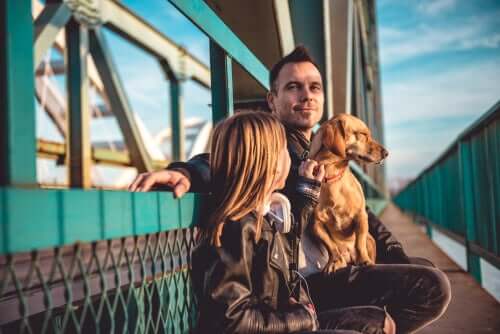 A man, a girl and their dog on a ferry.