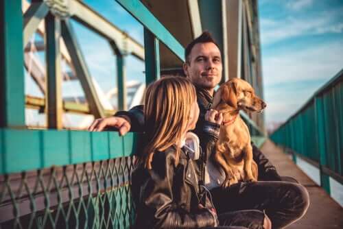 A man, a girl and their dog on a ferry.