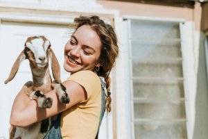 A woman holding a goat.