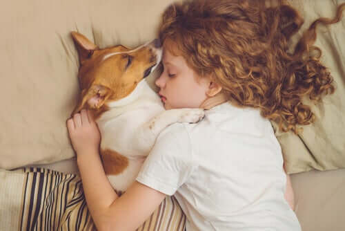 A girl sleeping with her dog. 