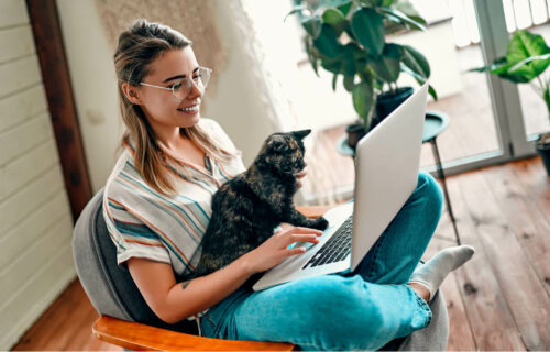 A woman holding a laptop and a lapcat.